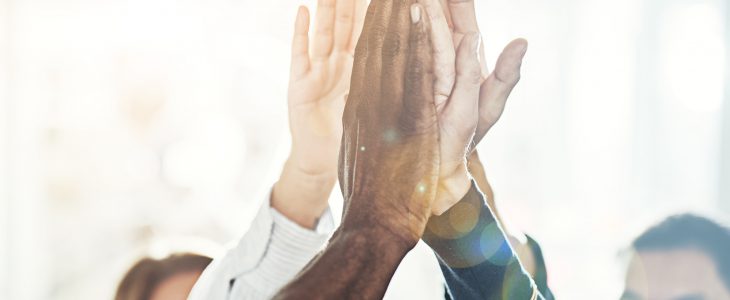 People high fiving together in an office