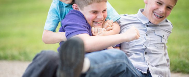 Three young boys roughhousing